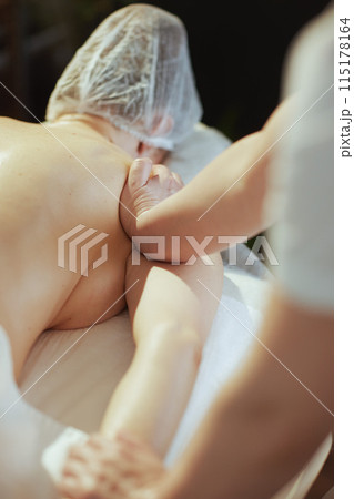Closeup on massage therapist in spa salon massaging clients arm Closeup on massage therapist in spa salon massaging clients arm 115178164