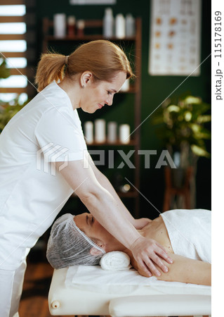 massage therapist massaging clients shoulder on massage table 115178169