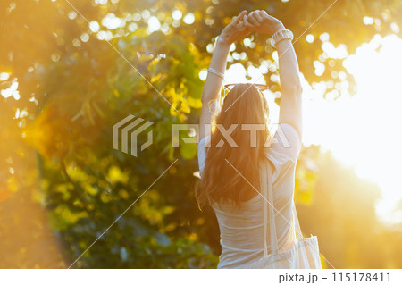 smiling modern woman in white shirt outdoors 115178411