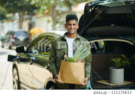 Man with Groceries Standing at Car Man with Groceries Standing at Car 115178633