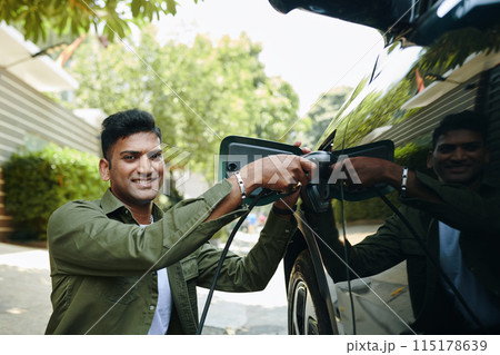 Indian Man Charging Electric Car 115178639