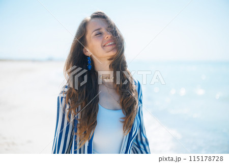 happy stylish woman on seacoast enjoying peace of mind happy stylish woman on seacoast enjoying peace of mind 115178728