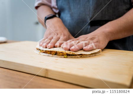Chef at the kitchen preparing quesadillas with tofu and sweet corn Chef at the kitchen preparing quesadillas with tofu and sweet corn 115180824