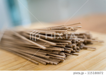 Cutting board with raw japanese buckwheat pasta Cutting board with raw japanese buckwheat pasta 115180872