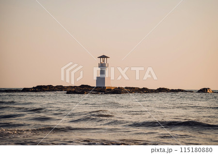 Lighthouse surrounded by water and cloudy sunset sky Lighthouse surrounded by water and cloudy sunset sky 115180880