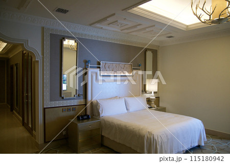 RAS AL KHAIMAH, UNITED ARAB EMIRATES - JUN 11, 2019: King-size bed in a luxurious hotel room in a five star hotel RAS AL KHAIMAH, UNITED ARAB EMIRATES - JUN 11, 2019: King-size bed in a luxurious hotel room in a five star hotel 115180942