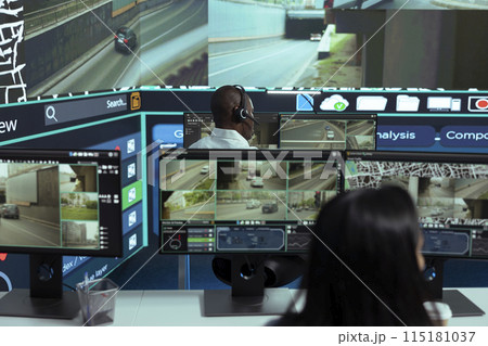 African american employee following delivery trucks around the city, sending gps coordinates for cargo location by using satellite map. Monitoring couriers in traffic on CCTV footage. 115181037