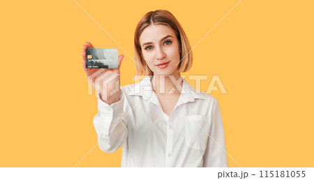 Online bank. Cashback offer. Best proposition. Financial success. Happy woman classy look presenting debit card isolated on yellow empty space. 115181055