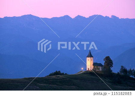 Church on a hill at dusk with mountain ranges in the background 115182083