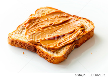 A close-up of creamy peanut butter evenly spread on a slice of toasted bread, showcasing a simple and delicious snack 115182193