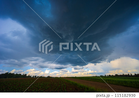 Dramatic storm clouds in blue sky associated with storm, dark, moody weather and looming atmosphere 115182930