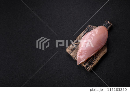 Fresh chicken fillet on a dark concrete table with spices and herbs 115183230