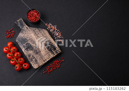 Black background with copy space with cherry tomatoes, salt, spices 115183262