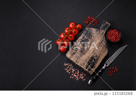 Black background with copy space with cherry tomatoes, salt, spices Black background with copy space with cherry tomatoes, salt, spices 115183268