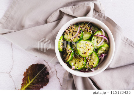 Close up of vegetarian salad of quinoa, cucumber and red onion in a bowl on the table top view 115183426