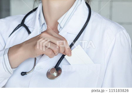Doctor puts an empty business card in his pocket close-up . Doctor puts an empty business card in his pocket close-up . 115183826