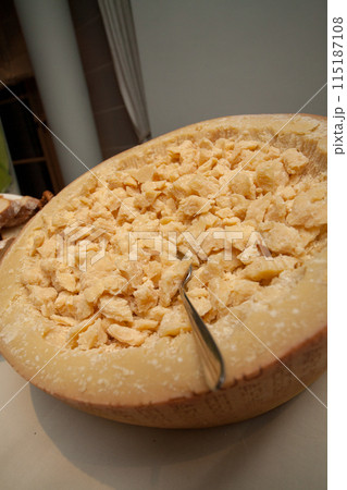 Wheel of Parmesan Cheese Chunks served with a Scoop, an Italian gourmet delicacy Wheel of Parmesan Cheese Chunks served with a Scoop, an Italian gourmet delicacy 115187108