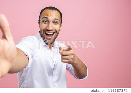 Excited man in white shirt making selfie pointing at you 115187372
