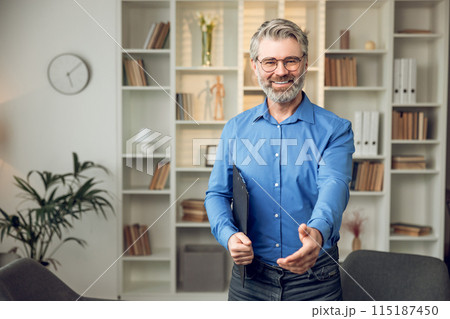 Happy male psychologist with clipboard looking at camera and smiling Happy male psychologist with clipboard looking at camera and smiling 115187450