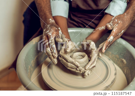 Hands of two people making a new pottery product together Hands of two people making a new pottery product together 115187547