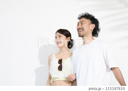夏の服で見上げるカップル　バカンスや観光、旅行など休日のイメージ 115187810