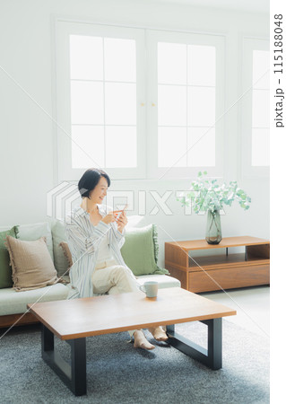 自宅でスマホを見るミドル女性　 115188048