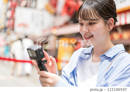 都会の繁華街で自撮り撮影をする若くて可愛い女性｜大阪観光イメージ｜大阪府大阪市道頓堀商店街 115190597