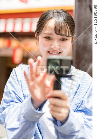 都会の繁華街で自撮り撮影をする若くて可愛い女性｜大阪観光イメージ｜大阪府大阪市道頓堀商店街 115190599