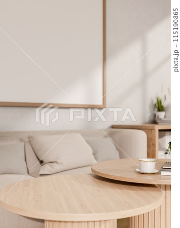 A round wooden coffee table in a minimalist contemporary living room features a comfy grey sofa. 115190865