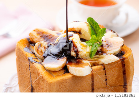 バニラアイスとチョコとバナナのハニートーストにチョコレートソースをかける 115192863