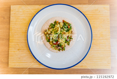 Tasty bean porridge with cauliflower and vegetables on white plate Tasty bean porridge with cauliflower and vegetables on white plate 115192972