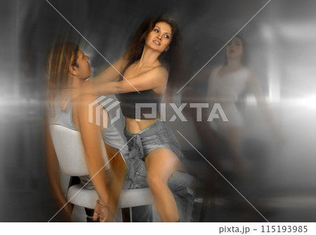 Man sits on chair and enjoys female company and charming lap dance in neon 115193985