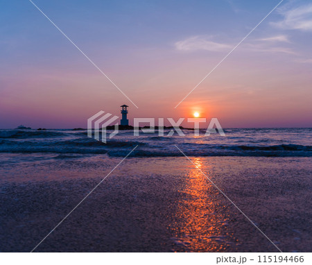 A lighthouse in the ocean during a beautiful sunset 115194466