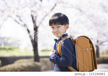 ランドセルを背負う小学1年生と桜並木　入学イメージ 115194961