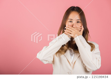 Asian happy portrait beautiful young woman standing smiling surprised excited her covering mouth with hands see only eyes and looking to camera on pink background with copy space for text 115199434