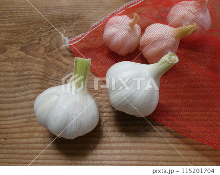 自然農法の家庭菜園で収穫したニンニクを野菜網に入れて保管する写真 自然農法の家庭菜園で収穫したニンニクを野菜網に入れて保管する写真 115201704