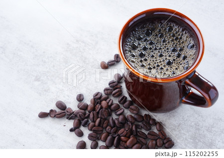 淹れたてで香りのよいコーヒーが入ったカップと、コーヒー豆 淹れたてで香りのよいコーヒーが入ったカップと、コーヒー豆 115202255