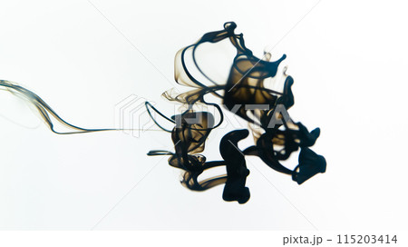 Black ink swirls forming delicate patterns as they diffuse elegantly through clear water, resembling an abstract ballet. Black ink swirls forming delicate patterns as they diffuse elegantly through clear water, resembling an abstract ballet. 115203414