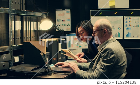 Investigators studying historical maps of crime scenes using federal classified records, officers reconstruct timelines using archived folders. Detectives conducting private investigation. Camera A. Investigators studying historical maps of crime scenes using federal classified records, officers reconstruct timelines using archived folders. Detectives conducting private investigation. Camera A. 115204139