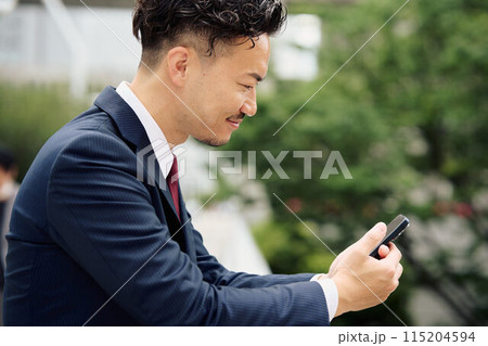 スマホを操作する都会のビジネスマン 115204594