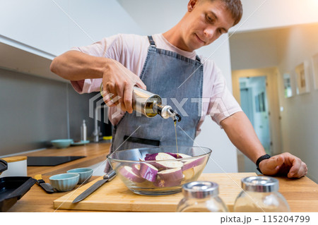 Chef at the kitchen preparing grilled eggplants with garlic 115204799