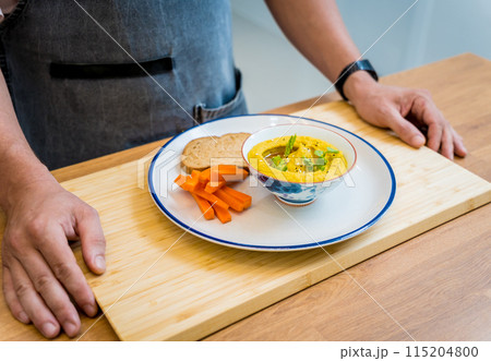 Chef at the kitchen preparing chickpea porridge with ginger 115204800