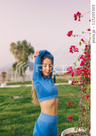 Young fitness woman in sports clothing stretching out in the park at sunny day. 115205303