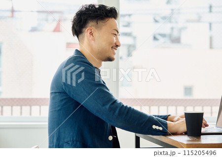 カジュアルな服装で働く男性 115205496