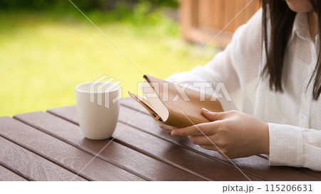 オープンカフェで本を読む若い女性 115206631