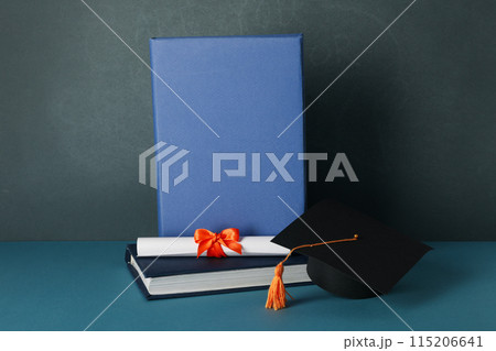 Graduate hat and books, on a blue background. 115206641