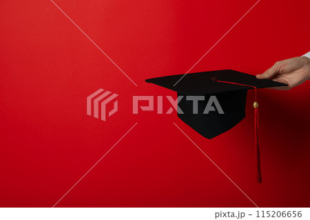 The hat of a university graduate, in his hands. 115206656