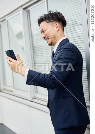 嫌な相手から着信がきたビジネスマン 115207016