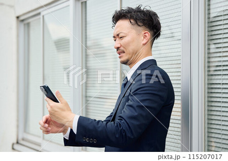 嫌な相手から着信がきたビジネスマン 115207017