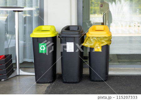 Colorful trash cans for sorting garbage. For plastic, glass, paper and others waste. Waste containers for garbage segregation in Poland, standing next to a wall 115207333